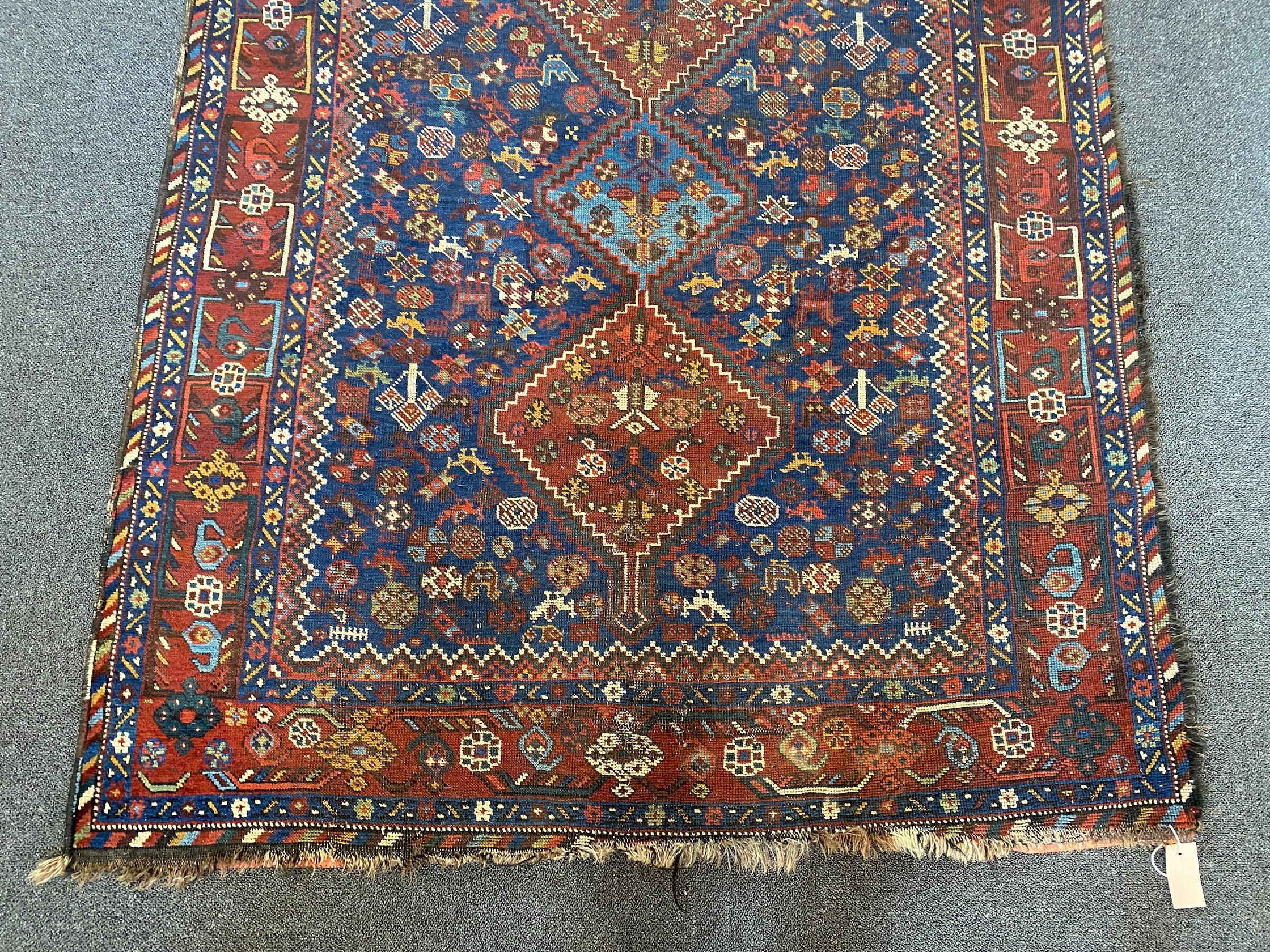 A Shiraz blue ground rug with triple lozenge medallion and floral border 160 x 122 cms.